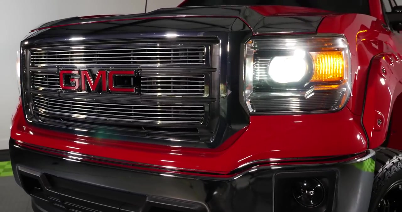 Removing plastic clips behind passenger-side headlight on GMC Sierra to access headlight bulb socket